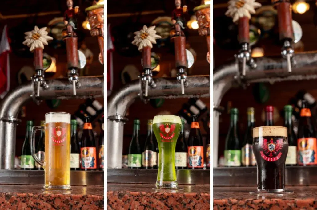 Três copos de chope servidos nas torneiras da cervejaria: claro, verde e escuro